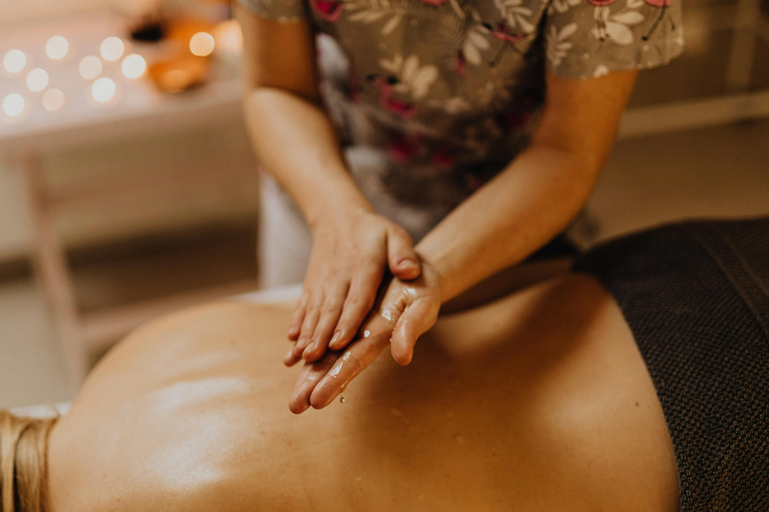 Massothérapeute appliquant de l'huile de massage sur les mains du client