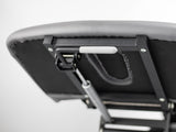 Détail du mécanisme de repose-pieds ajustable pour table de massage - Support blanc et structure noire